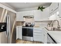 Bright kitchen with stainless steel appliances and white cabinets at 13606 E Bates Ave # 208, Aurora, CO 80014
