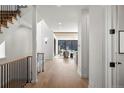Bright foyer with hardwood floors, featuring a staircase and an open view into the living area, creating a welcoming space at 4445 Wolff St, Denver, CO 80212