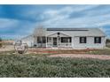 Single-Gathering house features a porch, tidy yard, a detached garage, and modern solar panels on roof at 34280 Columbine E Trl, Elizabeth, CO 80107