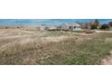 Wide shot of a single-Gathering home with a detached garage, dry grass yard, and a blue sky background at 34280 Columbine E Trl, Elizabeth, CO 80107