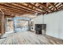 Spacious living room featuring wood floors and a brick fireplace at 1645 Tamarac St, Denver, CO 80220