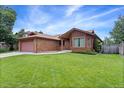 Well-maintained front yard showcasing the home's landscaping and brick exterior at 11686 W 74Th Way, Arvada, CO 80005