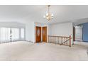 Open-concept living area with chandelier and staircase at 11686 W 74Th Way, Arvada, CO 80005