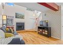 The living room features a decorative fireplace, wood floors, and a modern television and cabinet set at 6545 W 84Th Way # 132, Arvada, CO 80003