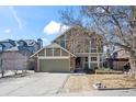 Charming two-story home featuring a well-maintained lawn, mature tree, and attached two-car garage at 4311 Del Rio Ct, Denver, CO 80239