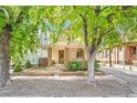 Charming bungalow featuring a quaint front porch and unique stone-accented columns and a beautiful stained glass front door at 3217 Irving St, Denver, CO 80211