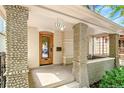 Close up on charming bungalow's quaint front porch and unique stone-accented columns and stained glass front door at 3217 Irving St, Denver, CO 80211