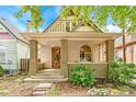 Charming bungalow features a quaint front porch and unique stone-accented columns and a beautiful stained glass front door at 3217 Irving St, Denver, CO 80211