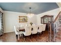 Formal dining room with chandelier, hardwood floors, and seating for eight at 9141 Roundtree Dr, Highlands Ranch, CO 80126