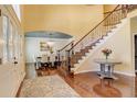 Elegant foyer with hardwood floors, a staircase with iron railing, and a view into the formal dining room at 9141 Roundtree Dr, Highlands Ranch, CO 80126