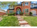 Charming brick home featuring a well-manicured lawn and a welcoming brick walkway to the front entrance at 9141 Roundtree Dr, Highlands Ranch, CO 80126