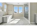 Bright bathroom featuring a soaking tub, a separate glass shower and dual windows at 9329 Russell Cir, Arvada, CO 80007