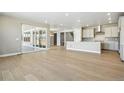 Spacious open-concept living area with wood floors, recessed lighting, and sliding glass doors to the patio at 9329 Russell Cir, Arvada, CO 80007