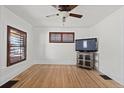 Bright living room featuring hardwood floors, plantation shutters, vintage furnishings, and tv at 3225 S Sherman St, Englewood, CO 80113