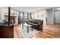 Inviting living room with stone fireplace, hardwood floors, and sliding glass doors to a balcony at 7468 S Alkire St # 205, Littleton, CO 80127