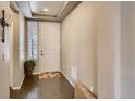 Welcoming entryway featuring hardwood floors, white door, and natural light from window at 5495 Espana Ct, Denver, CO 80249