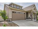 A two-car garage with a wide driveway and a covered front porch enhance the curb appeal of this home at 5495 Espana Ct, Denver, CO 80249