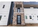 Up close detailed exterior showcasing stonework, two doors, and a small balcony, creating a modern look at 1524 Ingalls St, Lakewood, CO 80214