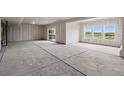 Unfinished basement with concrete floors, a sliding glass door, and three large windows, offering a blank canvas at 9382 Quaker St, Arvada, CO 80007