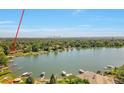 Picturesque lakefront home with boat docks and scenic views of the city skyline in the distance at 4790 W Evans Ave, Denver, CO 80219