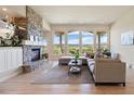 Bright living room with a stone fireplace, hardwood floors, and expansive windows with scenic views at 4002 Bell Mountain Dr, Castle Rock, CO 80104
