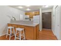 View of the kitchen and breakfast bar area featuring hardwood floors and stainless steel appliances at 9650 Huron St # 12, Thornton, CO 80260