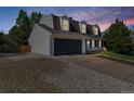 View of home featuring an attached two-car garage and driveway with a well-manicured lawn at 6330 E Irwin Pl, Centennial, CO 80112