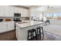 This kitchen has white cabinets, stainless steel appliances, and views of the open living room at 12597 W Big Horn Cir, Broomfield, CO 80021