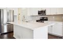 Modern kitchen with white cabinets and large island at 12597 W Big Horn Cir, Broomfield, CO 80021