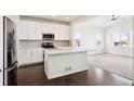 Modern kitchen with white cabinets, island, and stainless steel appliances at 12597 W Big Horn Cir, Broomfield, CO 80021