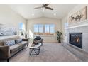 Inviting living room with vaulted ceilings, a cozy fireplace, and large windows offering scenic views of the neighborhood at 12597 W Big Horn Cir, Broomfield, CO 80021