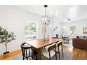 Bright dining room featuring a modern chandelier, hardwood floors and a large window, perfect for entertaining at 4363 N Raleigh St, Denver, CO 80212