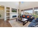 Inviting living room boasts a fireplace with built-ins, high ceilings, and large windows for plenty of natural light at 15961 Lookout Pt, Broomfield, CO 80023