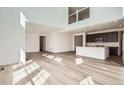 Open floor plan with plank flooring connecting the living area to the modern kitchen at 4600 Thistle Dr, Brighton, CO 80601