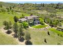 Expansive backyard with covered patio, a stone fireplace, and lush landscaping at 10370 Grande Vista Ct, Lone Tree, CO 80124