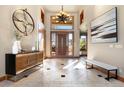 Elegant foyer with tile flooring, wooden door with transom window and designer lighting at 10370 Grande Vista Ct, Lone Tree, CO 80124