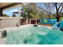 Backyard deck featuring a hot tub, outdoor seating, and lush green trees in the background at 978 Mercury Cir, Lone Tree, CO 80124