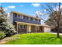 Inviting two-story home showcasing brick accents, gray siding, a charming porch, and a well-maintained lawn at 978 Mercury Cir, Lone Tree, CO 80124