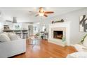 Bright living room with hardwood floors, fireplace, and open access to a modern kitchen with breakfast bar at 978 Mercury Cir, Lone Tree, CO 80124