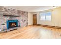 Bright living room with hardwood flooring, a brick fireplace with blue tiles, and a wooden front door at 155 S Pennsylvania St # 311, Denver, CO 80209