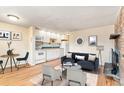 Inviting living room with hardwood floors, a brick fireplace, and an open kitchen layout with white cabinets at 155 S Pennsylvania St # 311, Denver, CO 80209