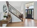 Inviting entryway featuring a staircase, hardwood floors, and natural light from the large front door at 10029 Winterthur Ct, Highlands Ranch, CO 80129