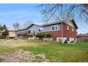 This ranch style home has gray and brick facade with manicured landscaping, and a two car garage at 12323 W Connecticut Dr, Lakewood, CO 80228
