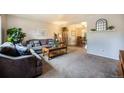 Comfortable living room featuring a neutral color scheme, a large sofa, and an open layout at 12323 W Connecticut Dr, Lakewood, CO 80228