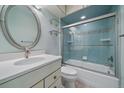 Bright bathroom with a shower-tub combination, white vanity, and a decorative oval mirror at 3420 Julian St, Denver, CO 80211