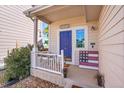 Inviting front porch with a vibrant blue door, welcome sign, and decorative American flag at 10521 Taylor Ave, Firestone, CO 80504