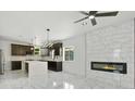 Open kitchen with stainless steel appliances, marble counters, and an adjacent fireplace at 3226 W Dakota Ave, Denver, CO 80219