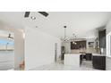 Modern kitchen with a center island, dark cabinetry, and marble flooring at 3226 W Dakota Ave, Denver, CO 80219