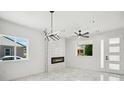 Bright, all-white living room with a modern fireplace and stylish light fixture at 3226 W Dakota Ave, Denver, CO 80219