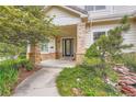 Inviting front entrance with a glass-paneled door, brick accents, and well-maintained landscaping at 22019 E Arbor Dr, Aurora, CO 80016